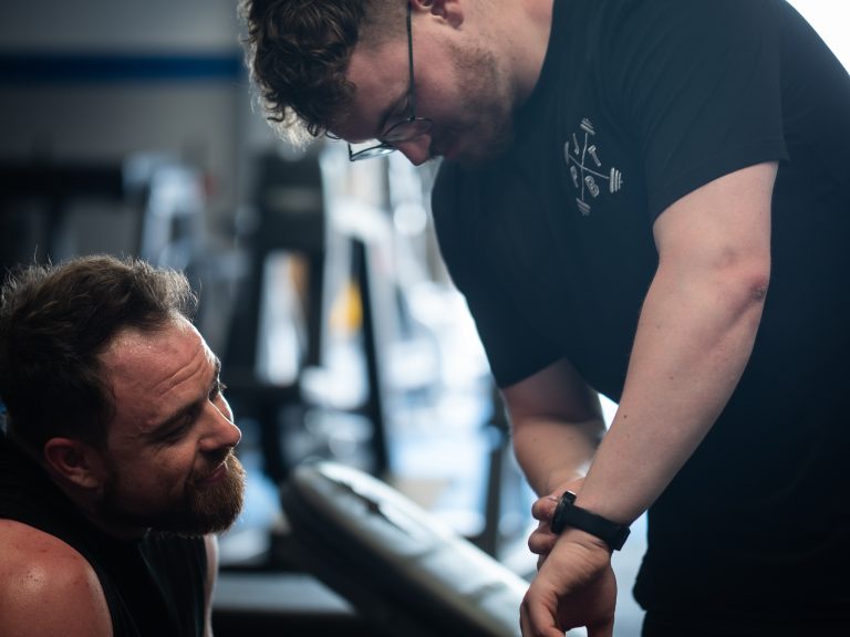 Fitness coach Basingstoke personal trainer showing client his fitness watch