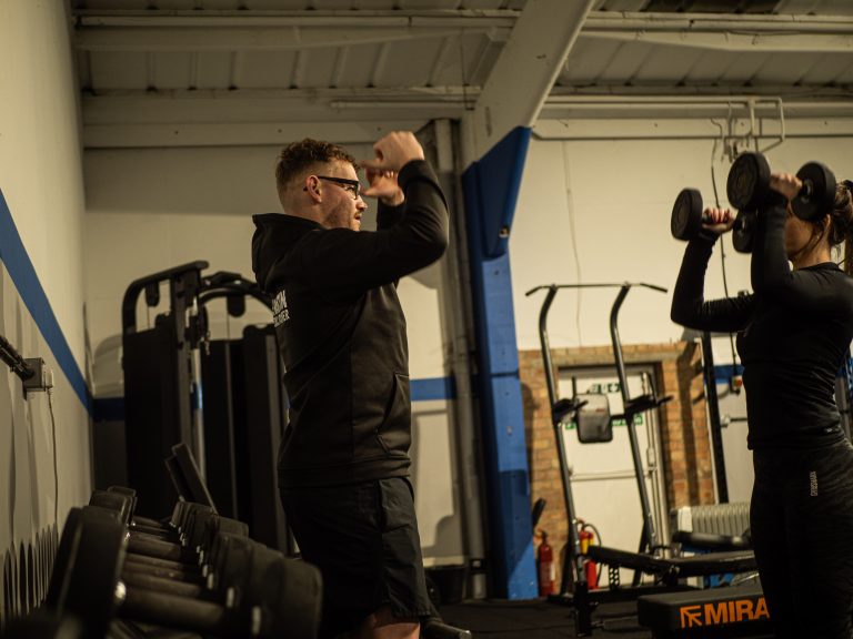 Strength coach Hampshire training client using dumbbells